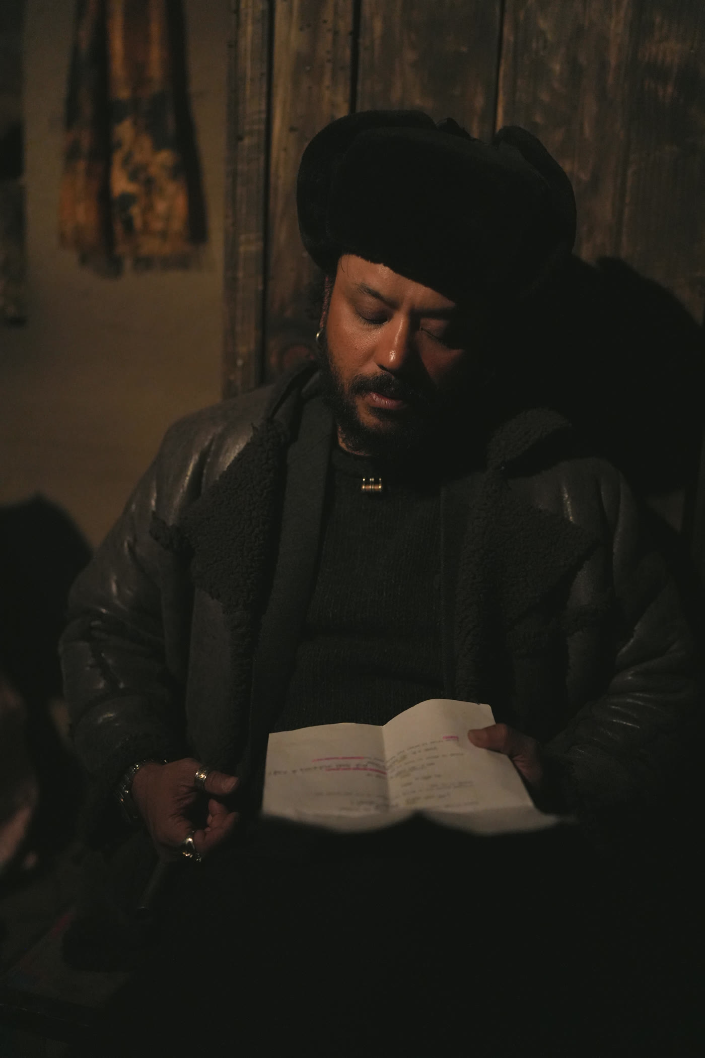Still from Himalayan Gold: a figure reads by candlelight